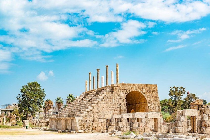 Ancient ruins with columns and a large archway. 5