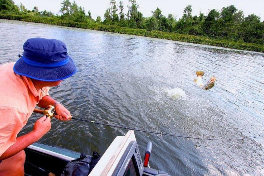 En person fisker fra en båd i en flod. 1