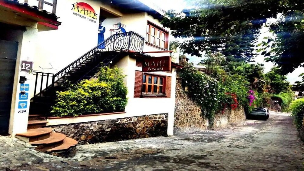 A building with a sign 'MAHE' and a staircase leading to the entrance. 2
