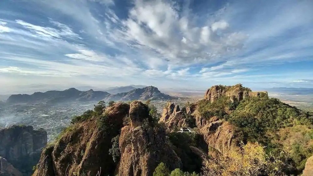 A mountainous landscape with rocky outcrops and a city in the distance. 3