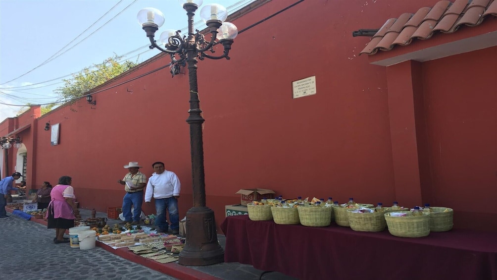 A street market with vendors and baskets of goods. 5