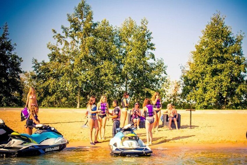 A group of people on a sandy beach with watercraft. 2
