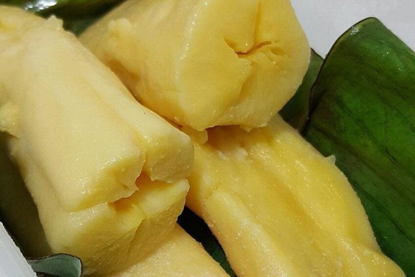 A close-up of yellow, peeled bananas on a green leaf. 4