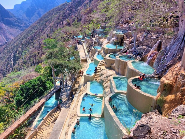 Piscinas escalonadas en una zona montañosa con gente nadando y paseando. 1