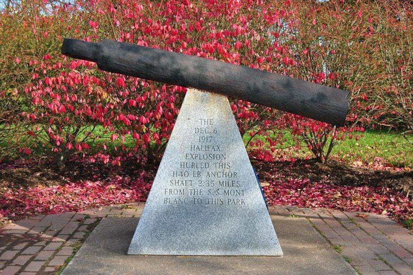Un monument en granit, agrémenté d’une plaque commémorative, se dressant sur fond d’arbres en fleurs. 2