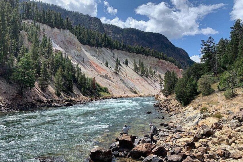 A river flowing through a rocky canyon with a forested mountain in the background. 4