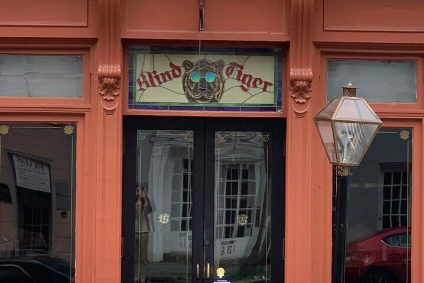 A storefront with a sign reading "Blind Tiger" and a decorative lion emblem. 1