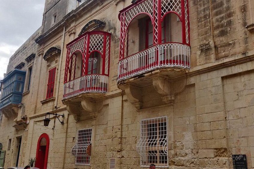 Un immeuble avec des balcons rouges et des balustrades blanches. 2