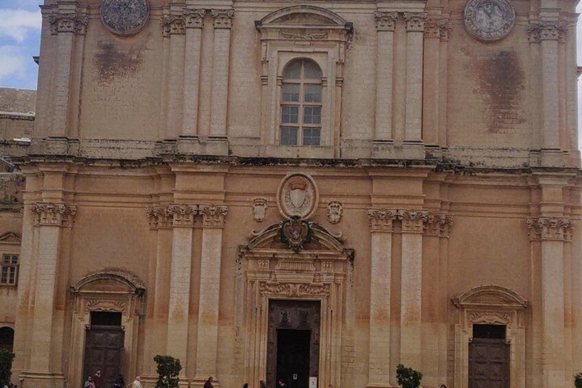 Un bâtiment historique doté d’une horloge centrale, de fenêtres en arc de cercle et d’une façade décorative. 3