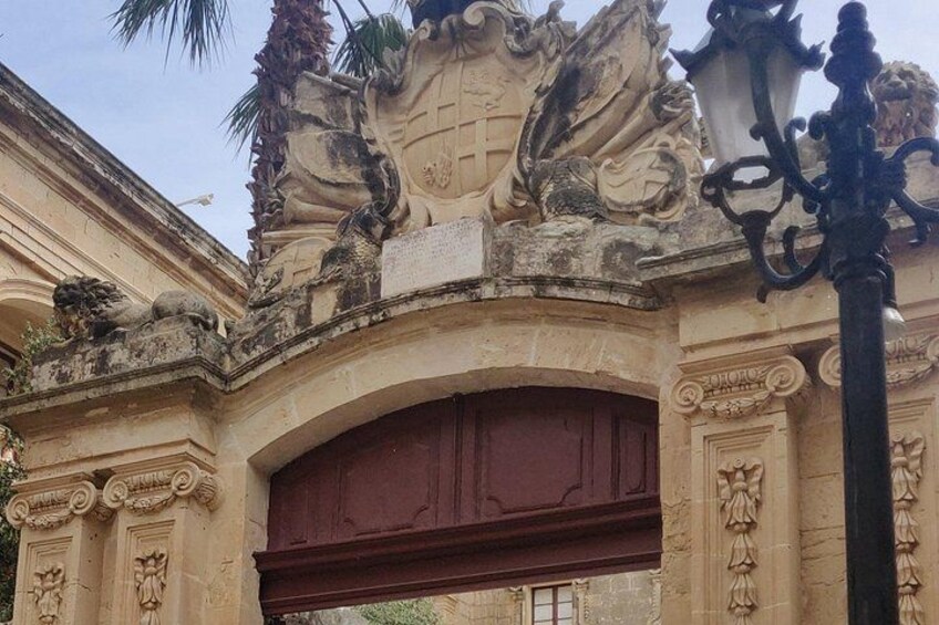 Un arc en pierre orné de sculptures complexes et surmonté d’une porte rouge. 5
