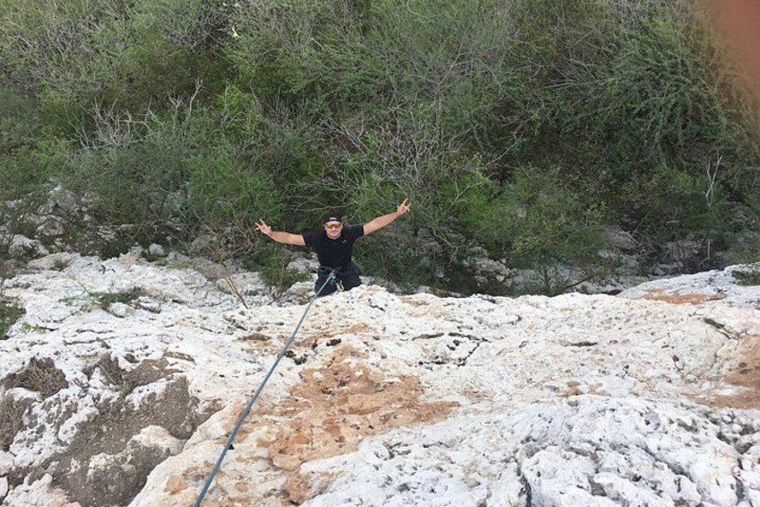 Una persona cala lungo un pendio roccioso usando una corda. 4
