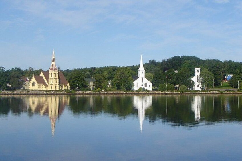 A calm lake with three churches reflecting on the water. 2