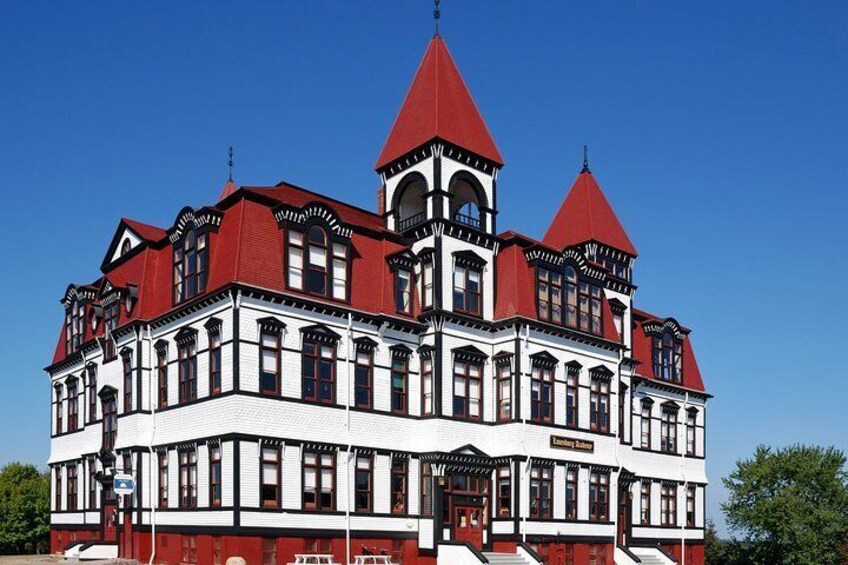 A large, ornate building with red and white trim, multiple towers, and a prominent clock tower. 5