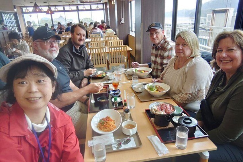 A group of people dining at a restaurant with various dishes and drinks on the table. 1