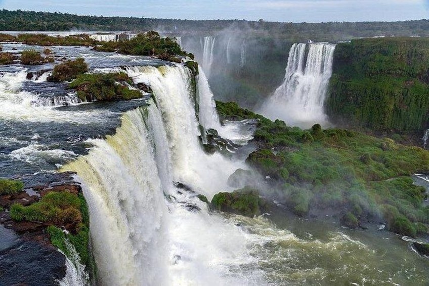 A multi-tiered waterfall with lush greenery around. 1