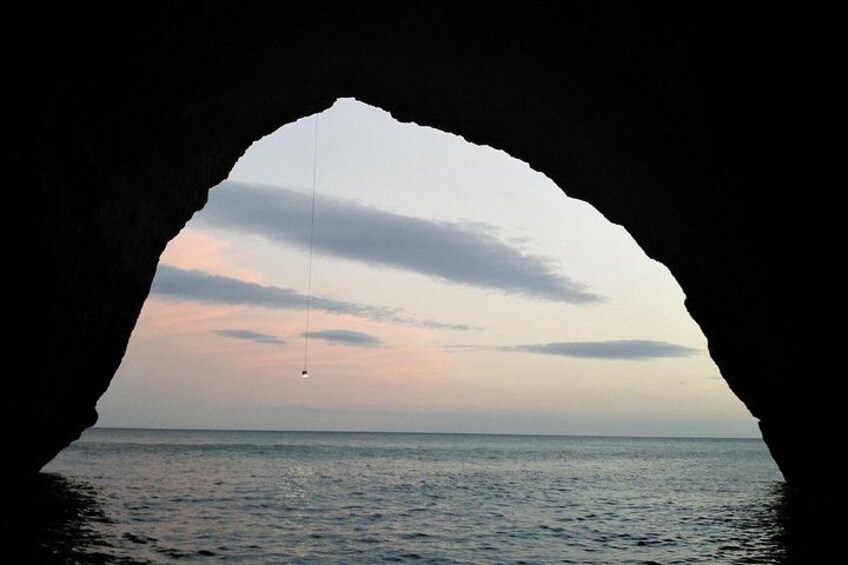 A cave opening with a view of the sea and a sky with clouds. 5