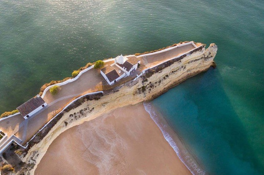 Eine Luftaufnahme einer Küstenbefestigung mit Strand und klarem Wasser. 1