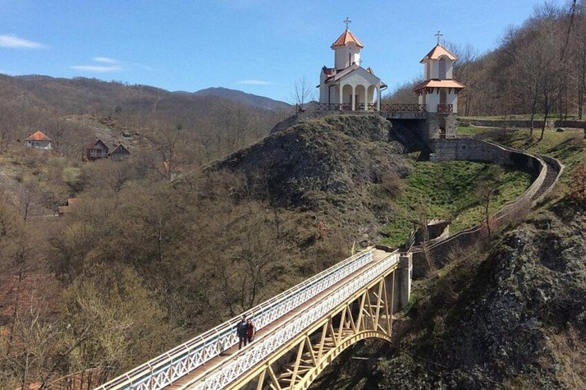 A bridge, two church towers, and a hilly landscape. 5