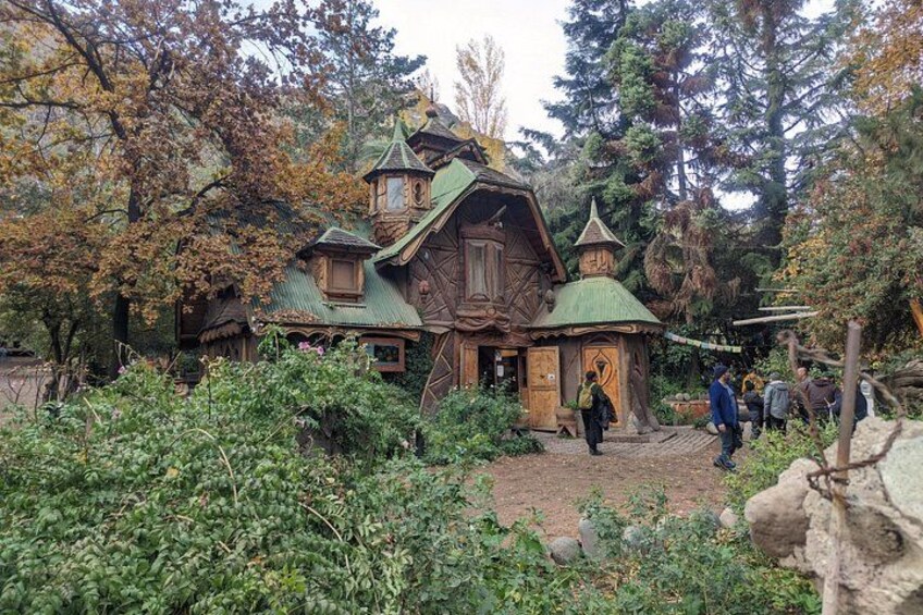 Eine Holzhütte mit grüner Dachdeckung, umgeben von Bäumen und Sträuchern. 5