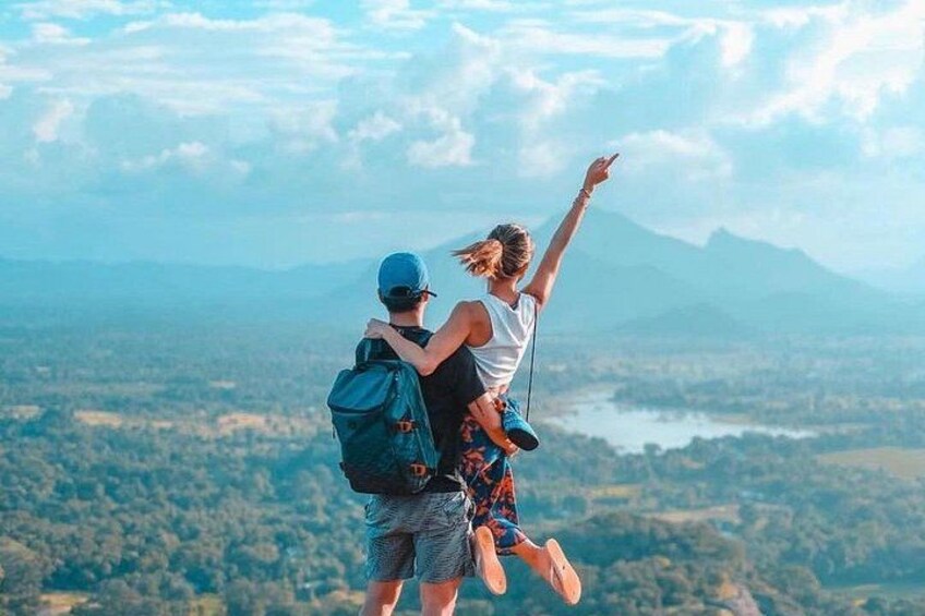 Twee personen springen, met een prachtig landschap op de achtergrond. 4