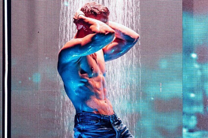 A person with blue body paint in a performance setting. 2