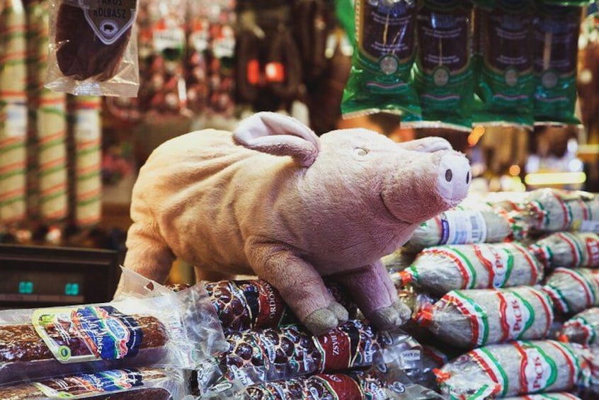 Un cochon en peluche est posé sur une étagère dans un magasin. 4