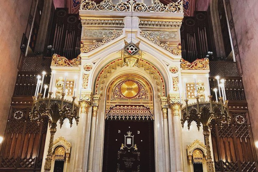 Une entrée de bâtiment richement décorée, avec des motifs dorés complexes et une étoile de David. 5