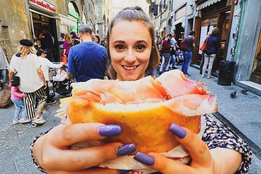 A person holding a large sandwich with visible meat and cheese. 1