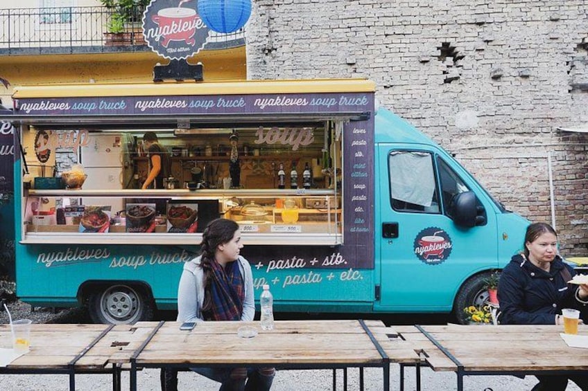 A food truck with a sign reading 'nyakleves soup truck' and a menu listing pasta and soup. 2