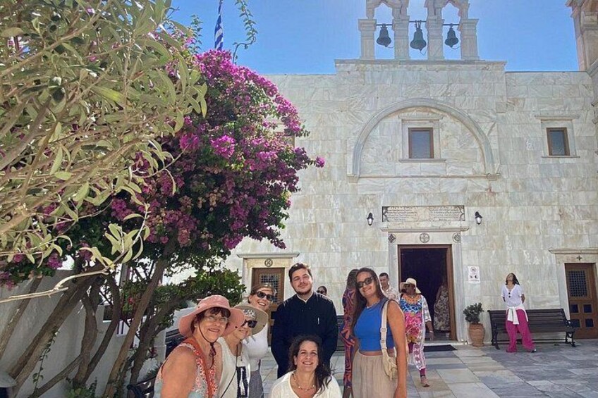Un groupe de personnes posant devant un bâtiment historique doté d’un clocher. 2