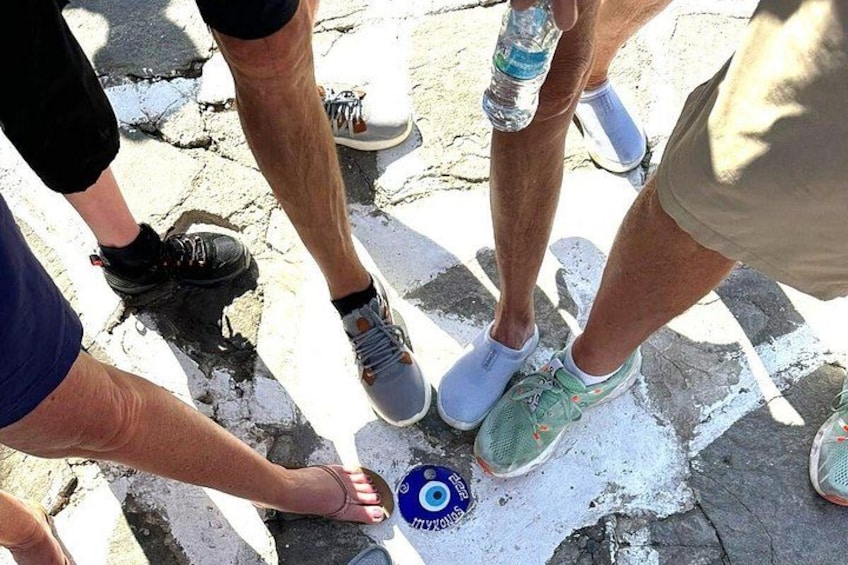 People standing on a cracked pavement with a blue circular object on the ground. 1