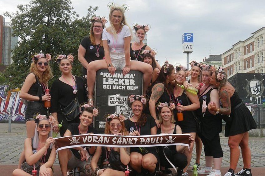 Eine Gruppe von Personen posiert mit einem Banner in einer Stadt. 2