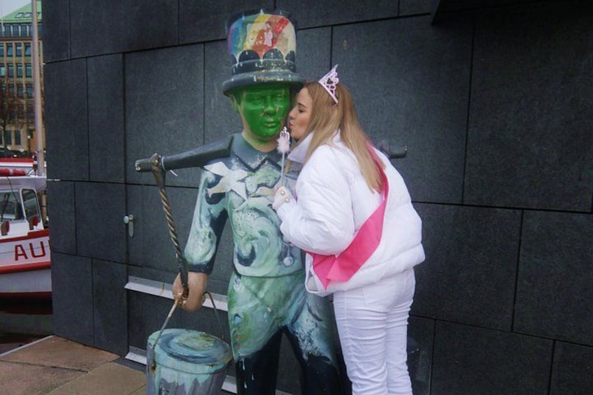 A person in a green costume with a paint bucket and a person in a white outfit with a sash. 2