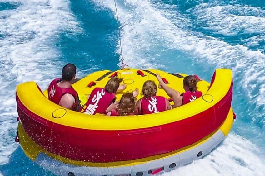 En grupp människor i en gul och röd uppblåsbar flotte på ett vattendrag. 5
