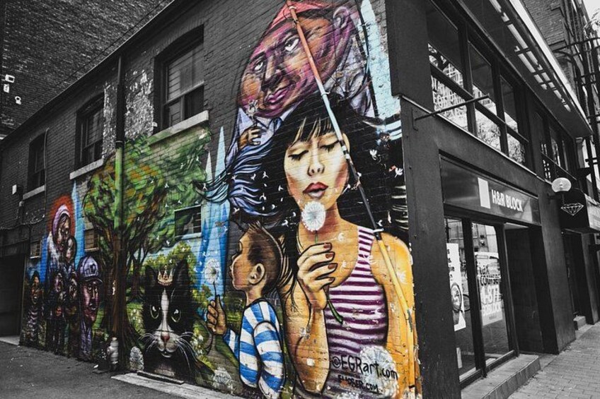 Une fresque colorée orne le mur d’un bâtiment et représente différents personnages et scènes. 1
