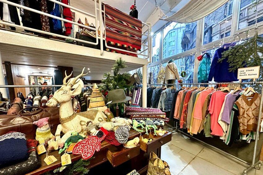 Un magasin de vêtements où l’on trouve des portants remplis de vêtements et une sélection d’objets traditionnels coréens. 2
