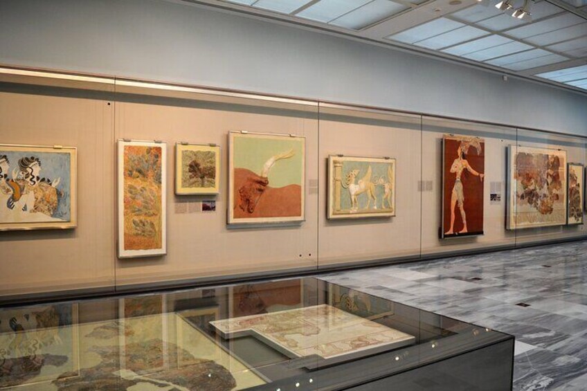 An art gallery with paintings on the wall and a glass display case with a map. 4