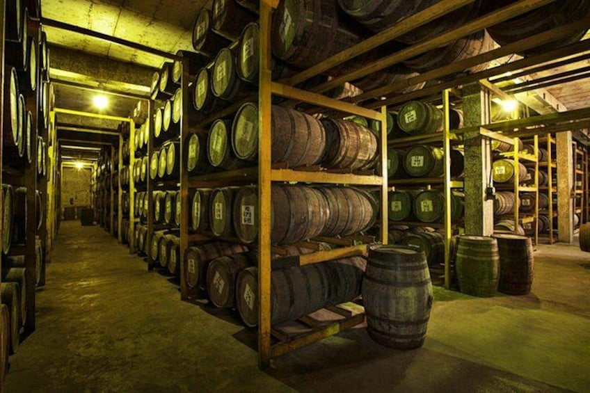 A warehouse with wooden shelves stacked with barrels. 4