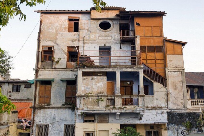 Un edificio a più piani con un balcone, una finestra tonda e una scala. 2