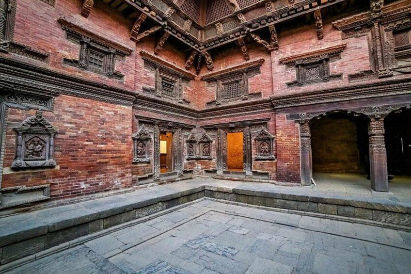 Un cortile con pareti in mattoni rossi, travi in legno e decorazioni elaborate. 5