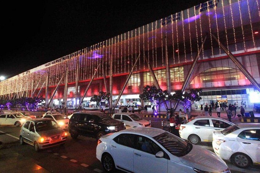 Un edificio luminoso dal design moderno, circondato da un parcheggio con diverse auto. 4