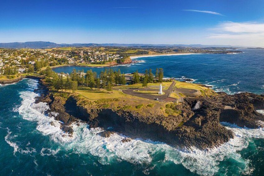 Un pueblo costero con un faro, costa rocosa y una bahía. 2