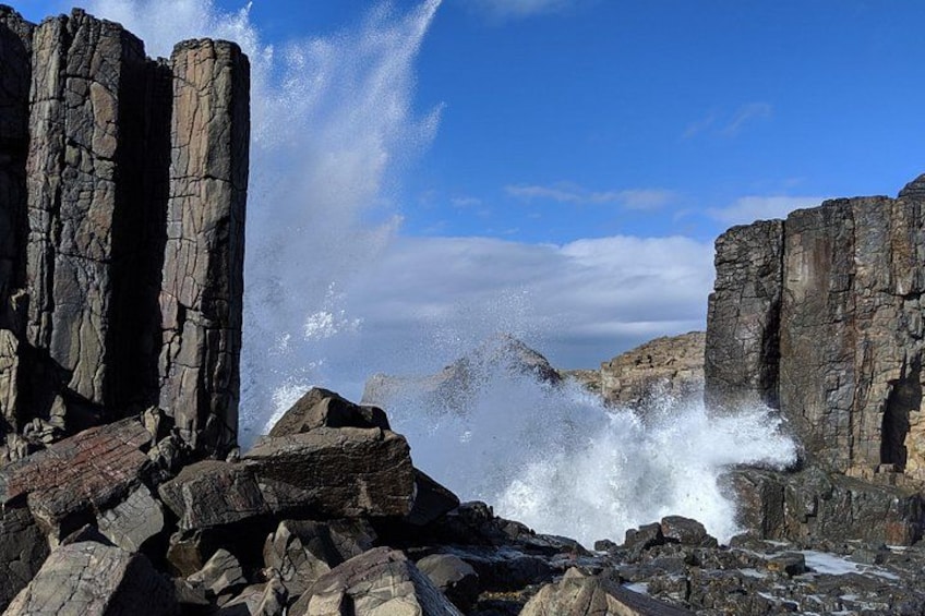 Acantilados rocosos, olas rompiendo y cielo despejado. 1