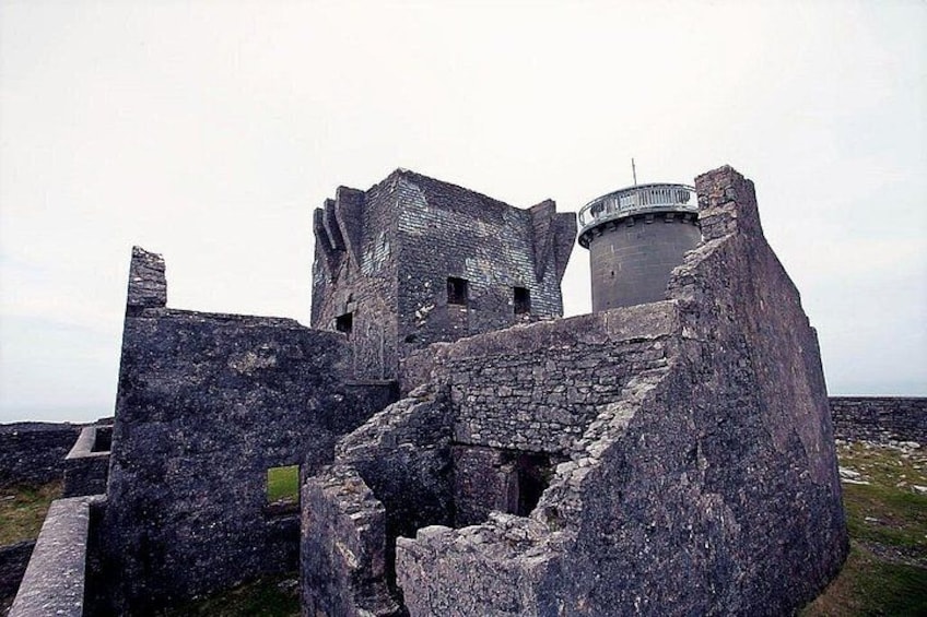 A historic stone castle with a round tower and a large, open courtyard. 4