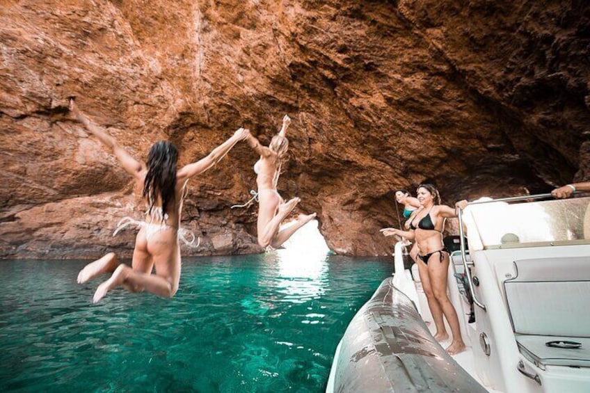 People jumping into water from a boat in a rocky cave. 5