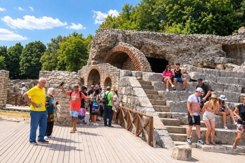 Turister ved et gammelt arkæologisk sted med stenvidner og gelænder. 5