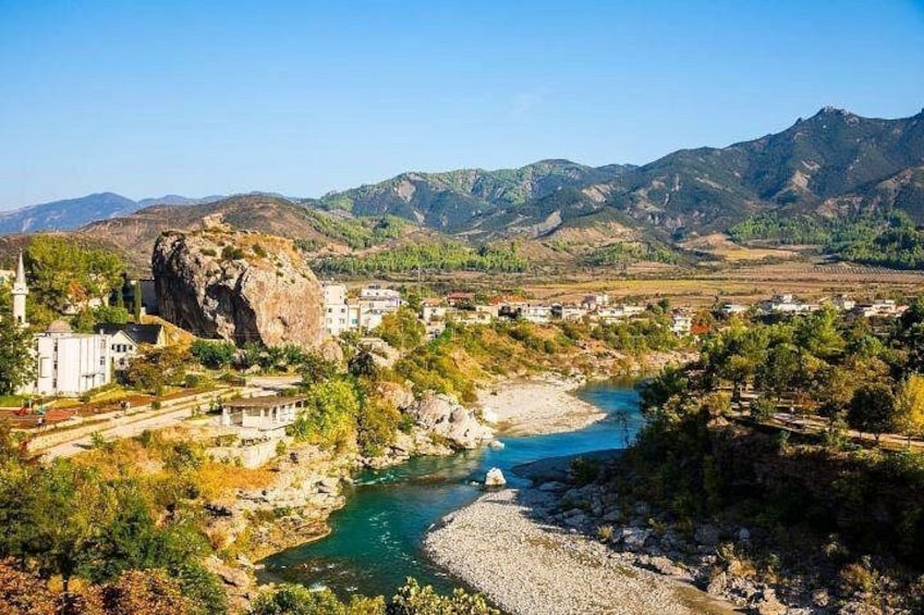A river flowing through a town with mountains in the background. 4