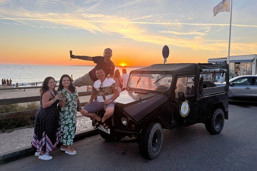 Tramonto su una spiaggia, buggy da sabbia e persone che posano. 1