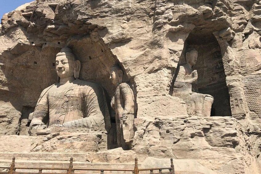 Large stone Buddha statues carved into a cliff face. 1