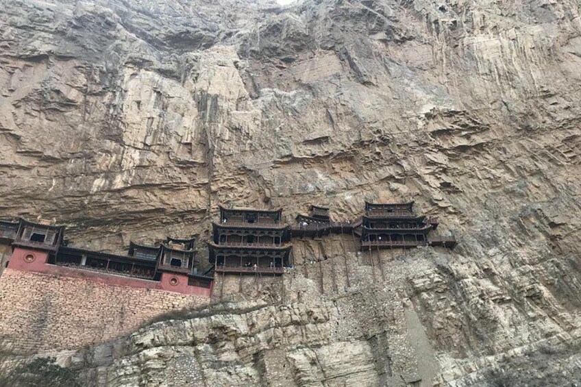 A cliffside with traditional multi-tiered buildings. 5